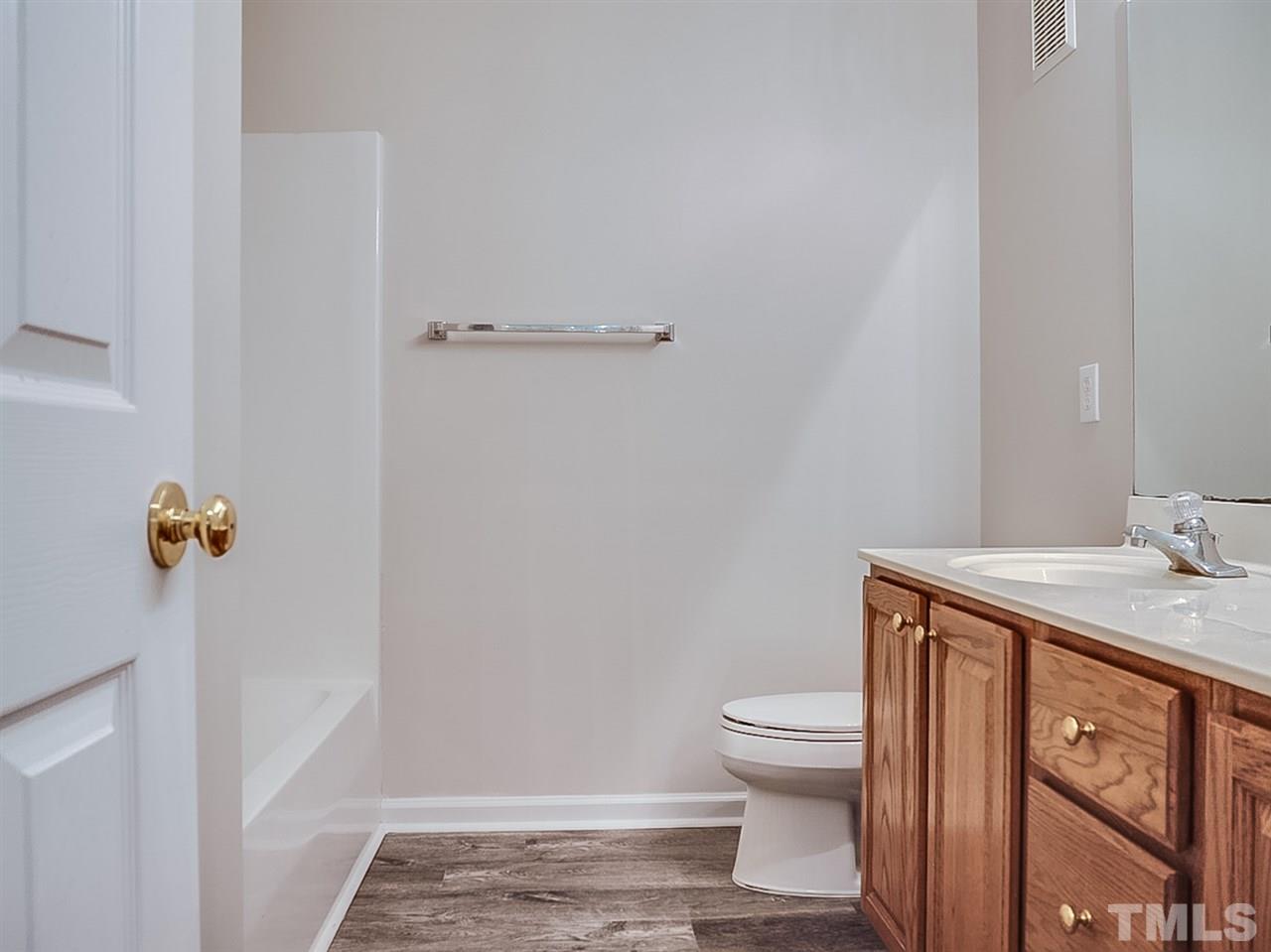 332 Springfork Drive Cary, NC 27513 - Photo 13 of 15 a bathroom with a granite countertop sink a toilet and a shower