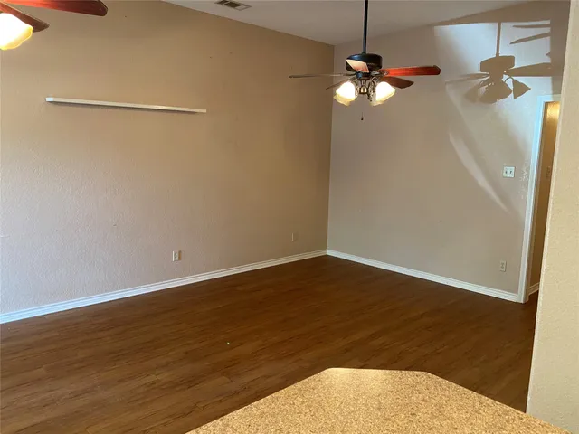 a view of a room with wooden floor and a chandelier