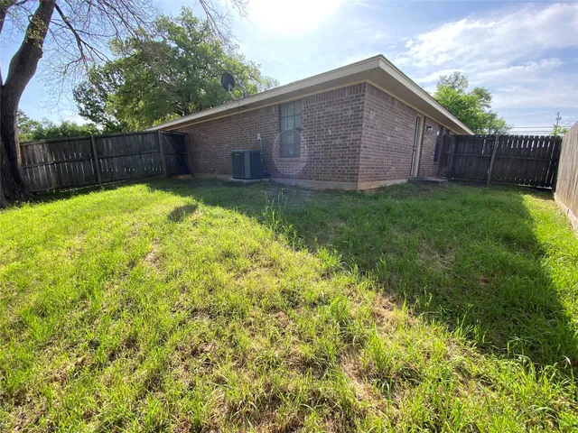 a view of a backyard with a small cabin and wooden fence