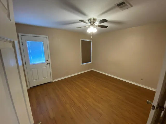 a view of an empty room with wooden floor