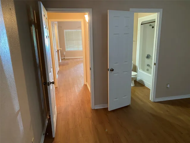 a view of a hallway with wooden floor