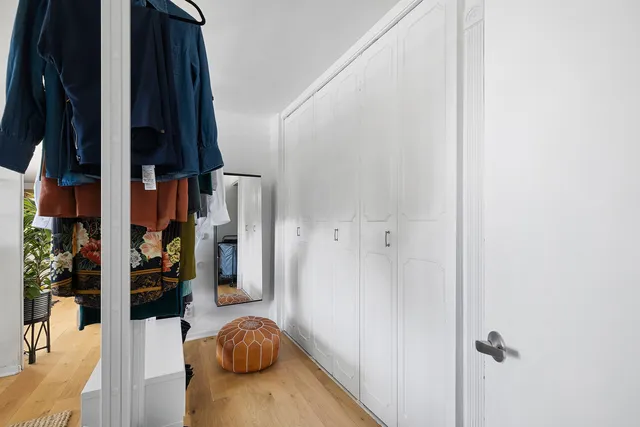 a bedroom with a bed a dresser and potted plants
