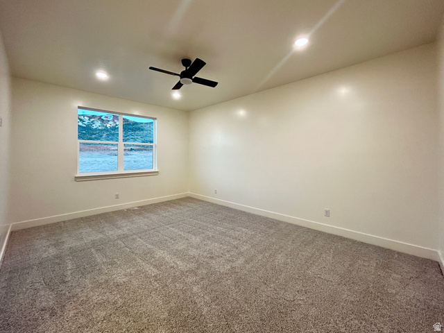 6 South 450th West Gunnison, UT 84634 - Photo 25 of 45 Spacious room featuring neutral carpet, a large window with white trim, recessed lighting, a ceiling fan, and mountain scenery