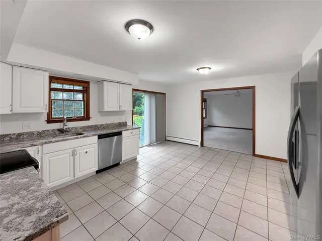 a large kitchen with a stove a sink dishwasher a refrigerator and a granite counter tops