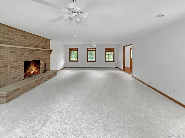 an empty room with windows and fireplace