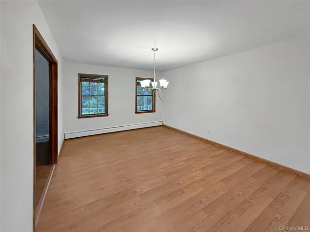 an empty room with windows and chandelier