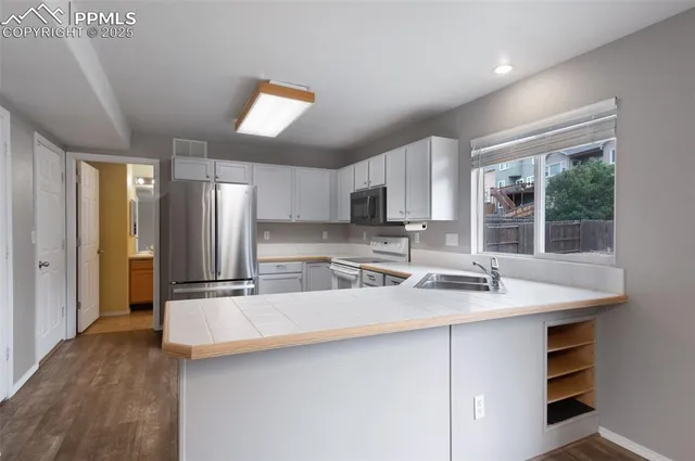 a kitchen with a sink a center island cabinets and a window
