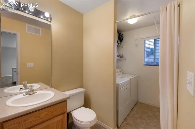 a bathroom with a toilet a sink a mirror and vanity