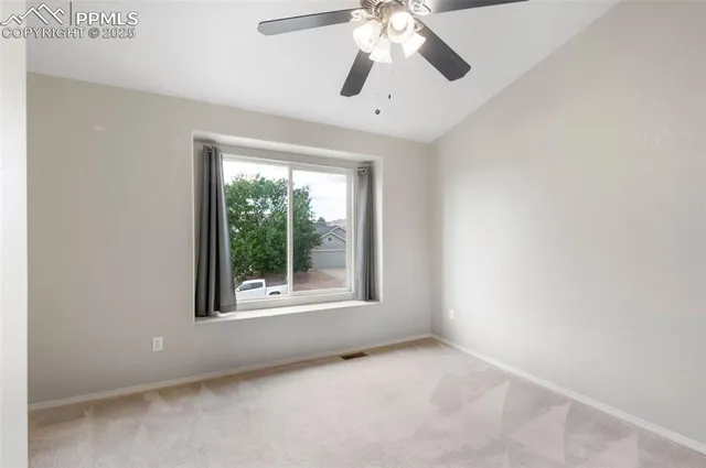 an empty room with a window and a fan
