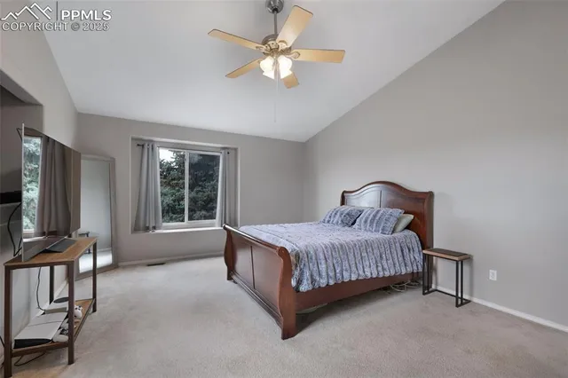 a bedroom with a bed flat screen tv and a large window