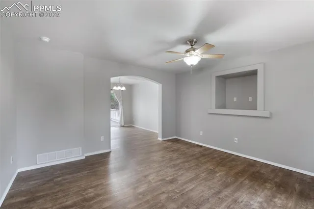 a view of an empty room with a ceiling fan and a window