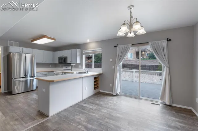 a kitchen with stainless steel appliances granite countertop a stove refrigerator and cabinets