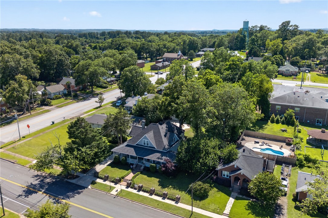 110 South Fairplay Street Seneca, SC 29678 - Photo 48 of 50 An aerial perspective reveals a charming property nestled amidst mature trees, featuring a welcoming facade and a delightful backyard swimming pool.