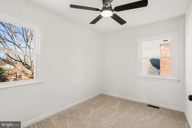 an empty room with a window and a fan