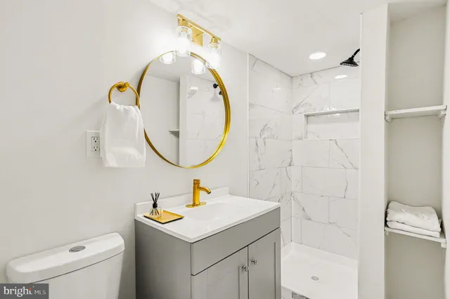 a bathroom with a sink mirror vanity and toilet