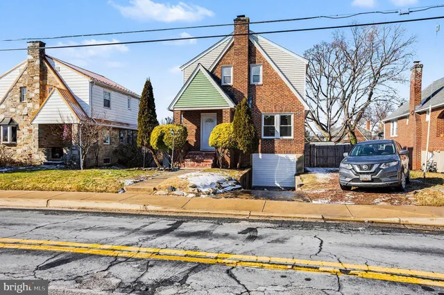 a front view of a house with swimming pool and sitting area