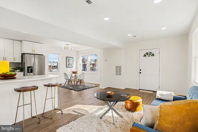 a living room with furniture and a dining table with wooden floor