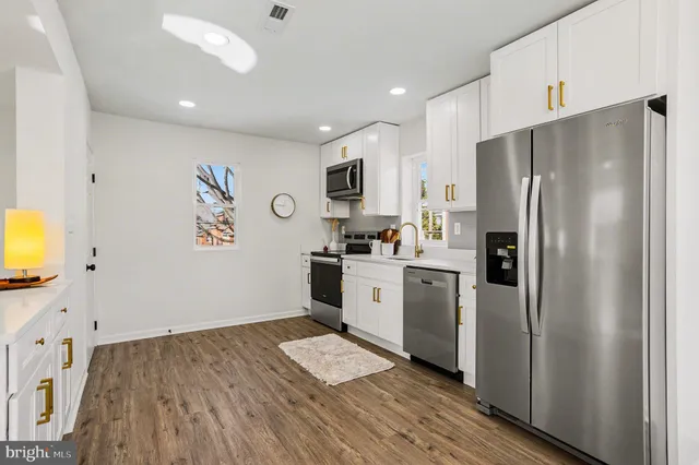 a kitchen with a refrigerator cabinets and wooden floor