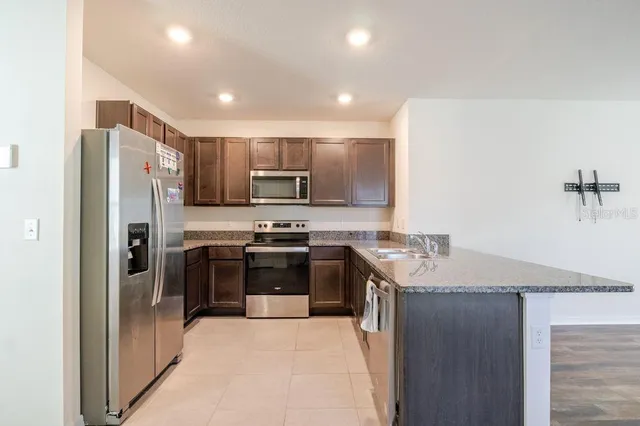 a kitchen with stainless steel appliances granite countertop a refrigerator and a stove