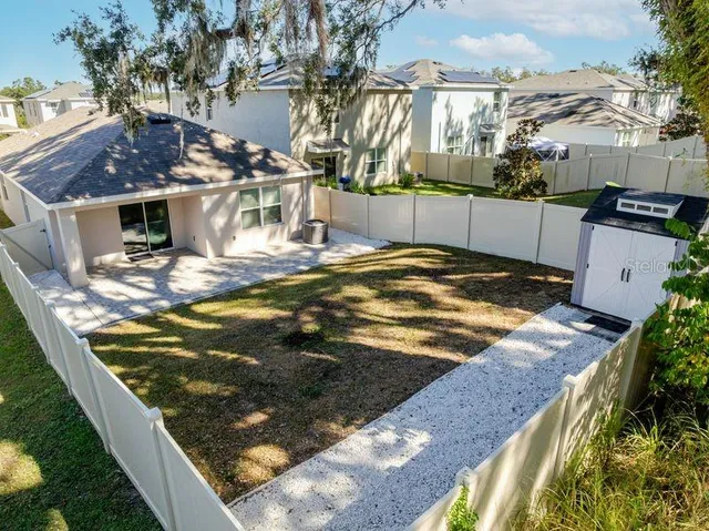 a view of a yard with wooden fence