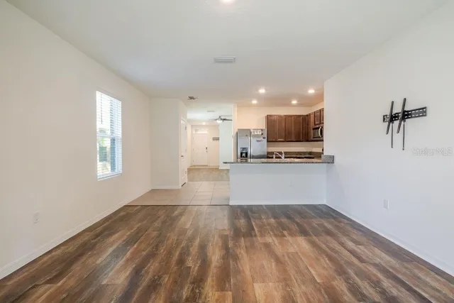 a view of kitchen with wooden floor and electronic appliances