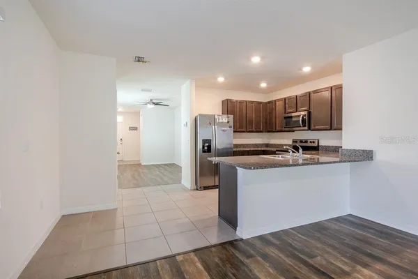 a kitchen with stainless steel appliances granite countertop a refrigerator and a sink