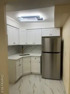 a kitchen with a refrigerator sink and cabinets
