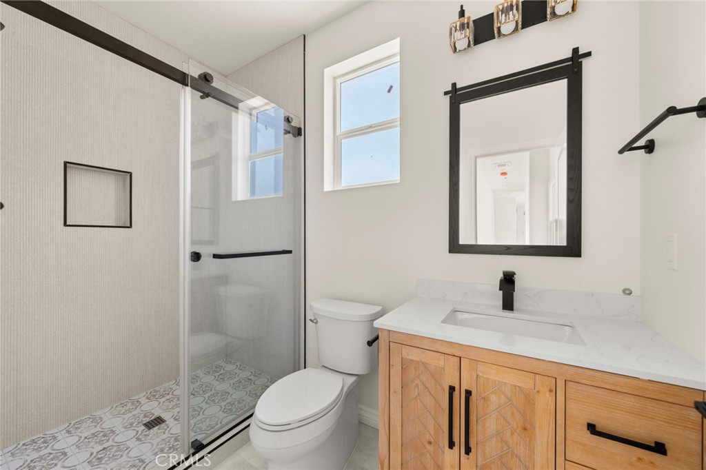 5978 Copperfield Avenue Riverside, CA 92506 - Photo 18 of 37 a bathroom with a granite countertop toilet sink and shower
