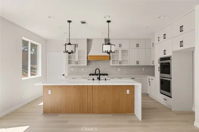 a kitchen with stainless steel appliances granite countertop a sink a stove and a refrigerator