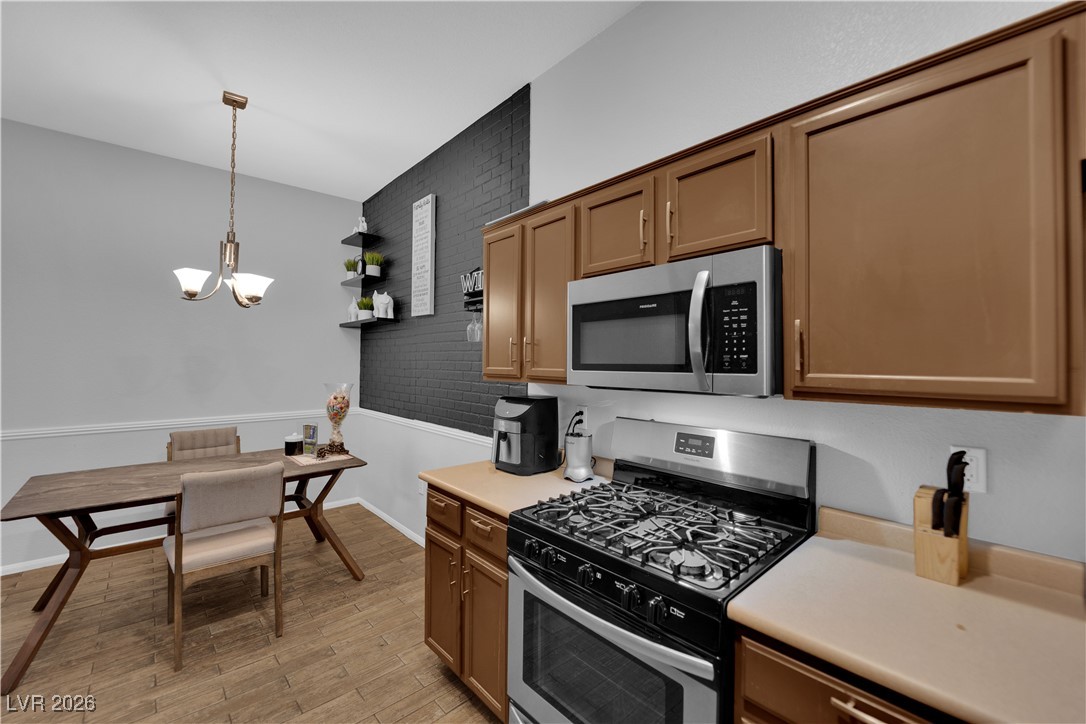 2305 West Horizon Ridge Parkway, Unit 3512 Henderson, NV 89052 - Photo 20 of 29 Kitchen with appliances with stainless steel finishes, light countertops, decorative light fixtures, light wood-style floors, and a chandelier