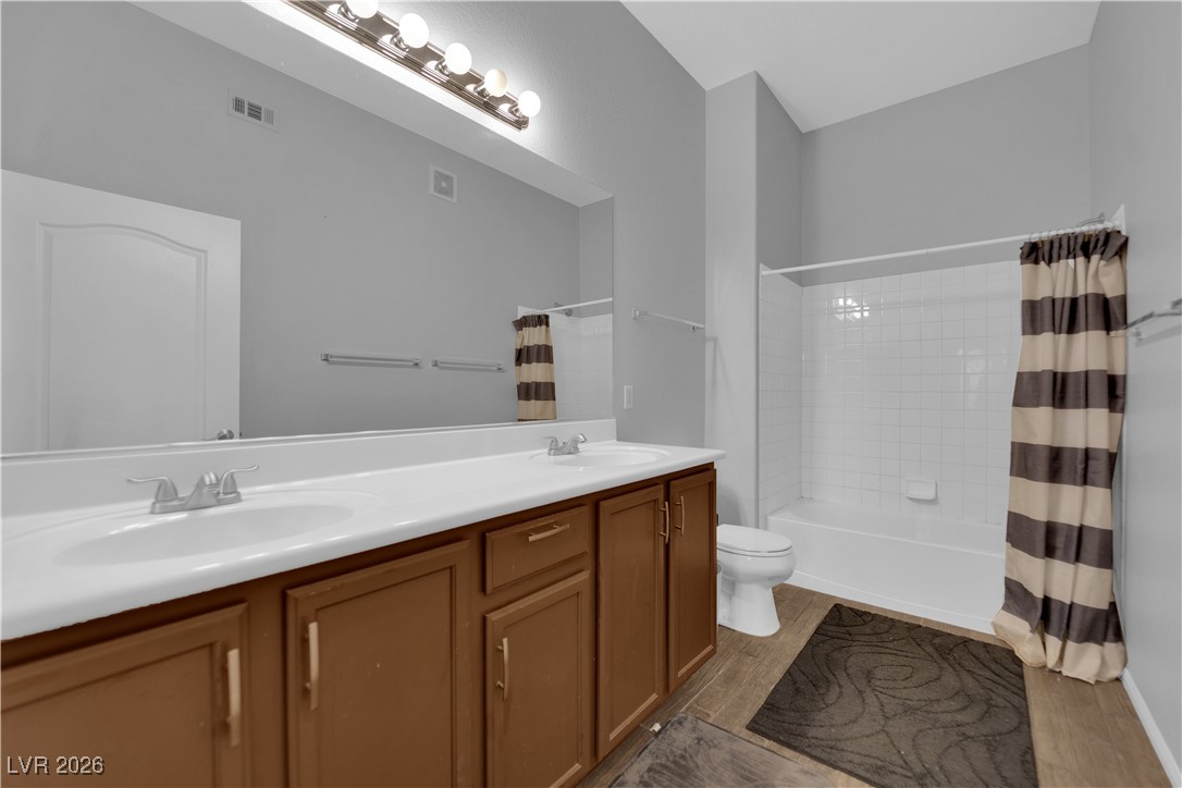 2305 West Horizon Ridge Parkway, Unit 3512 Henderson, NV 89052 - Photo 9 of 29 Full bath featuring double vanity, dark wood-style floors, and shower / tub combo with curtain