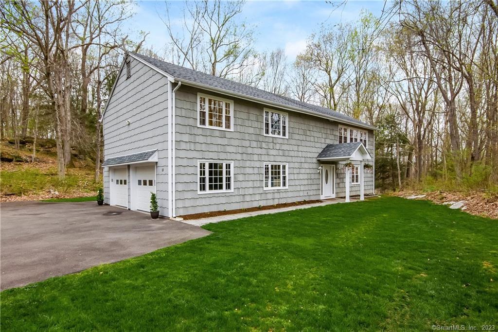 a front view of a house with a garden and yard