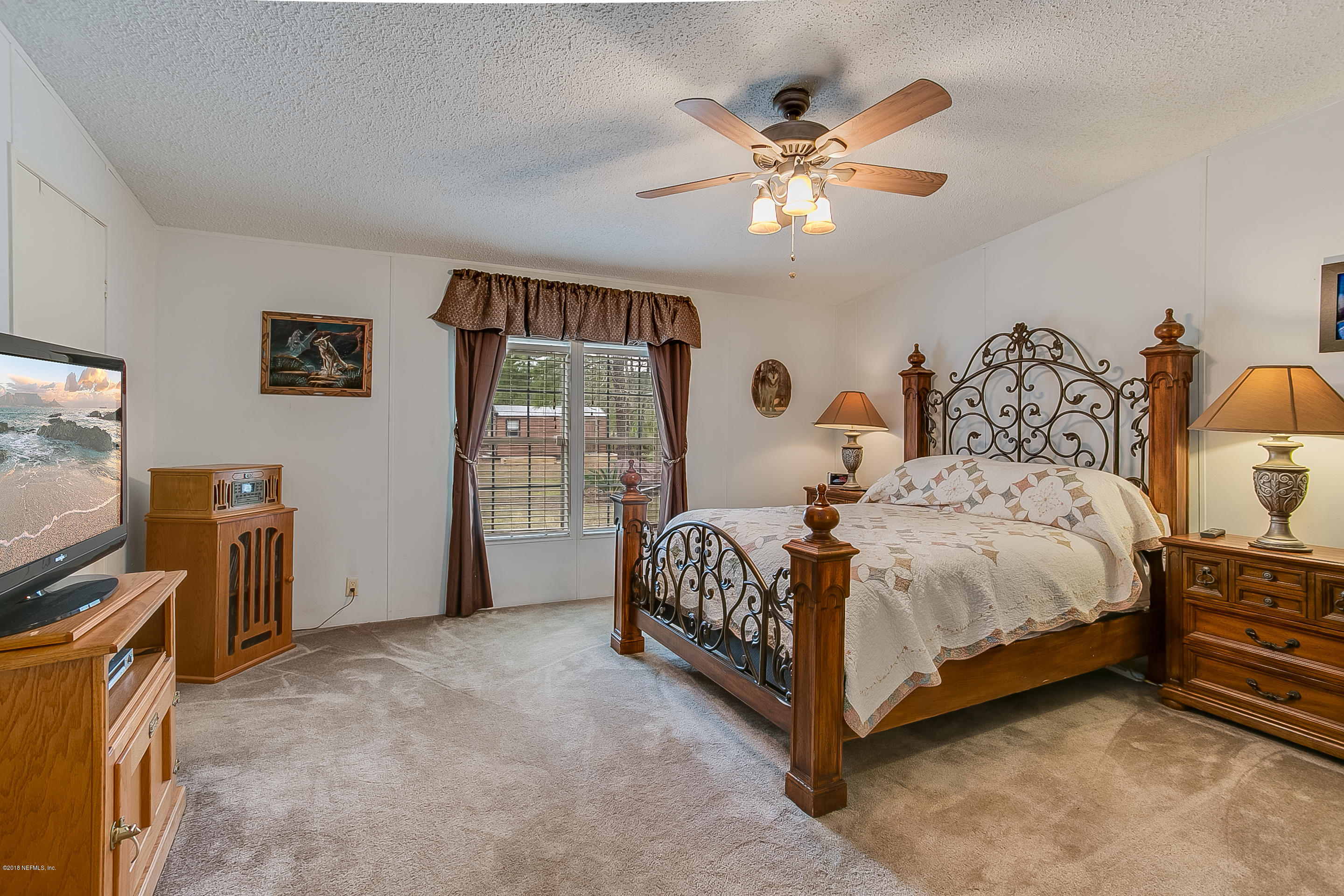 13278 Grover Road Jacksonville, FL 32226 - Photo 11 of 26 a bedroom with a bed and a flat tv screen on dresser