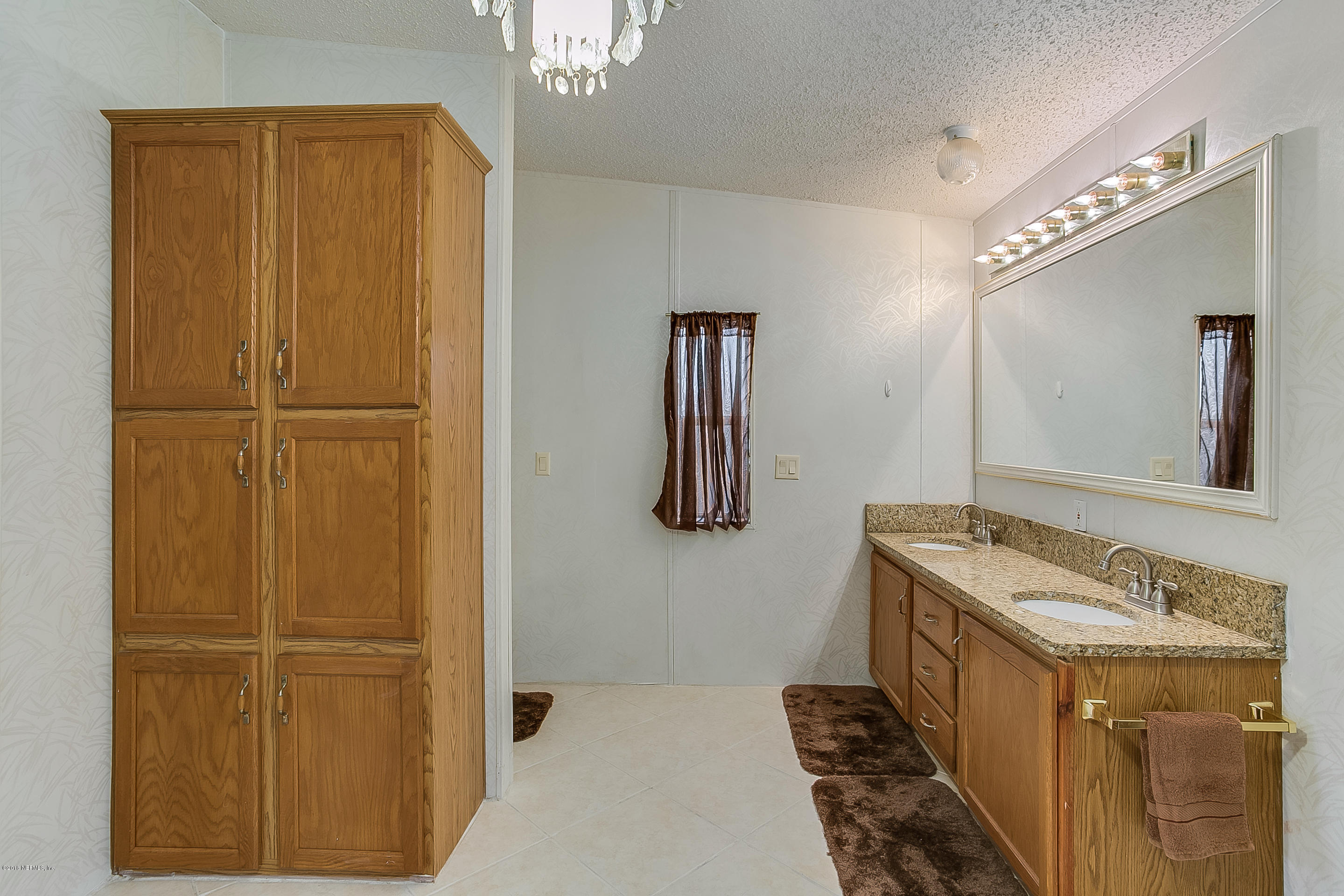 13278 Grover Road Jacksonville, FL 32226 - Photo 12 of 26 a bathroom with a granite countertop sink a mirror and a shower