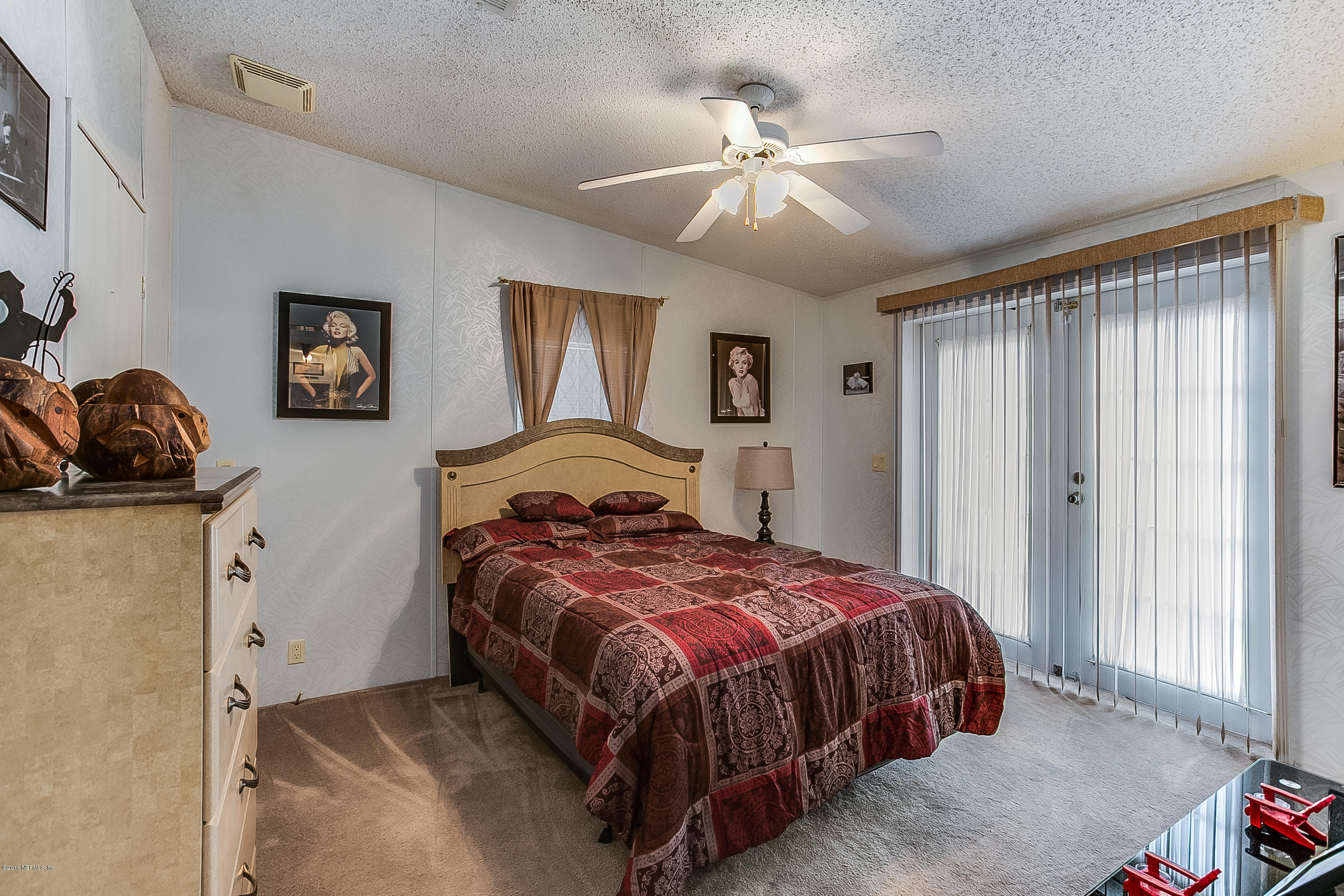 13278 Grover Road Jacksonville, FL 32226 - Photo 17 of 26 a bedroom with a bed and a chandelier