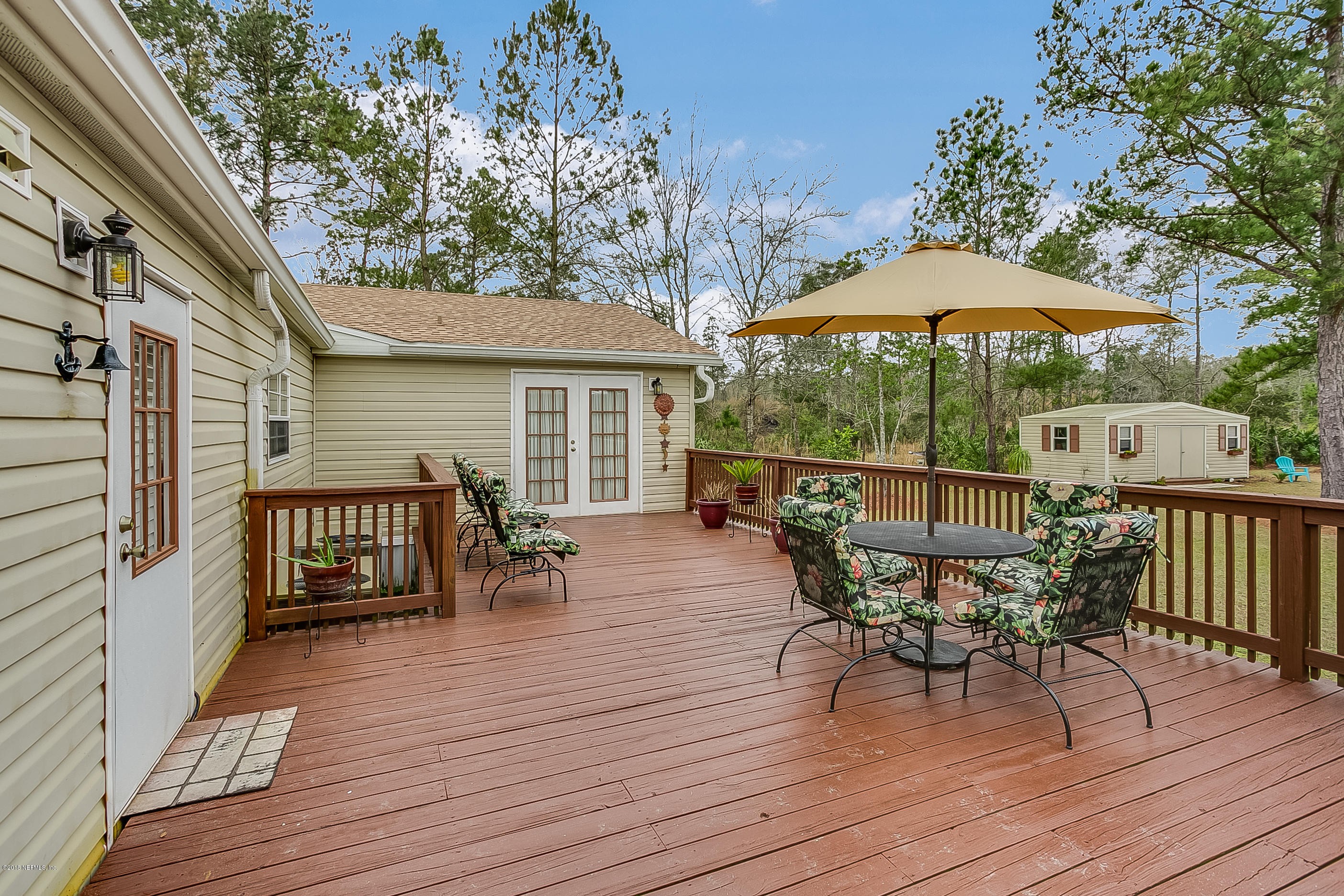 13278 Grover Road Jacksonville, FL 32226 - Photo 22 of 26 a view of a roof deck with table and chairs under an umbrella with wooden floor