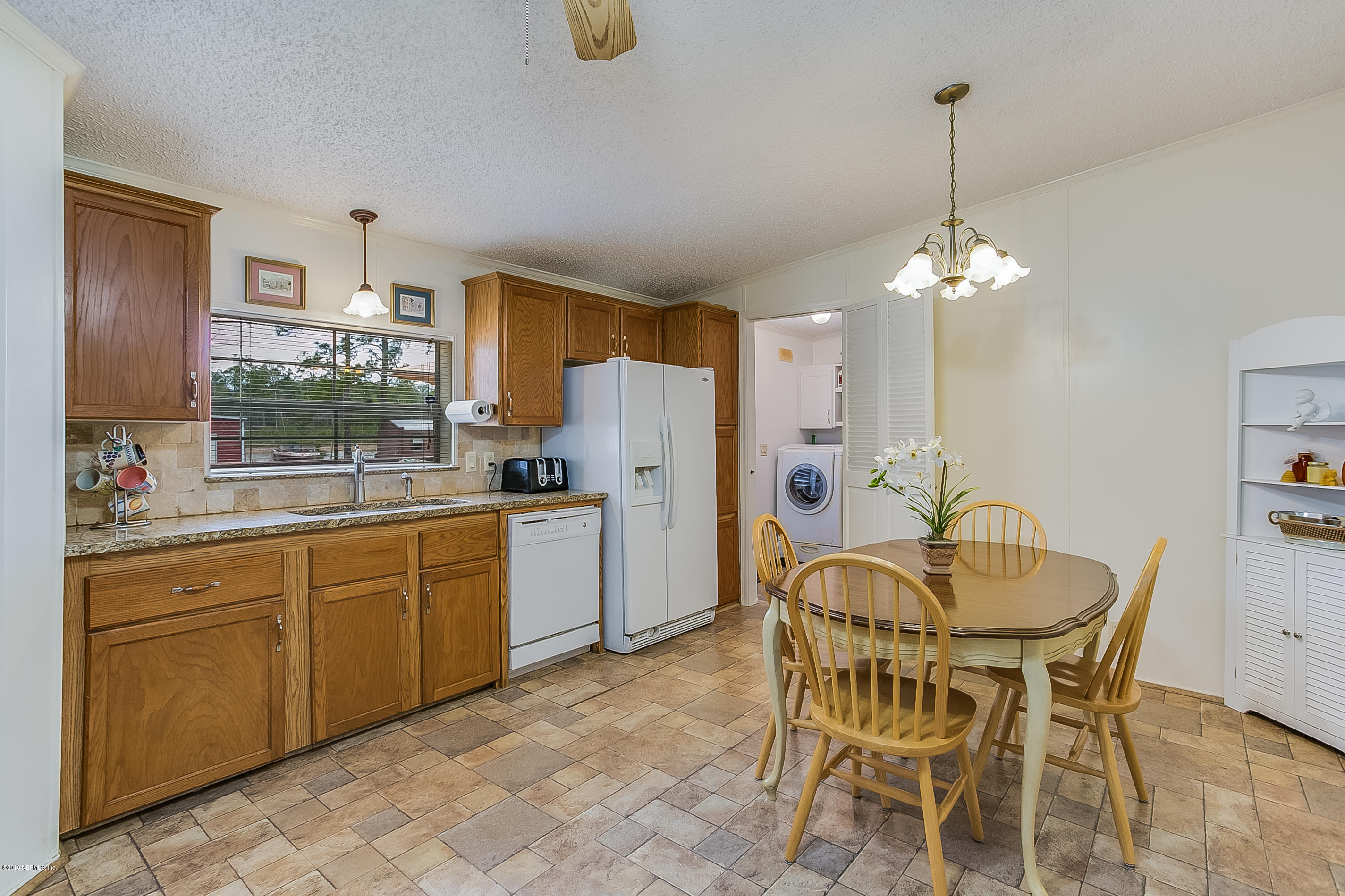 13278 Grover Road Jacksonville, FL 32226 - Photo 6 of 26 a kitchen with stainless steel appliances a dining table chairs and chandelier