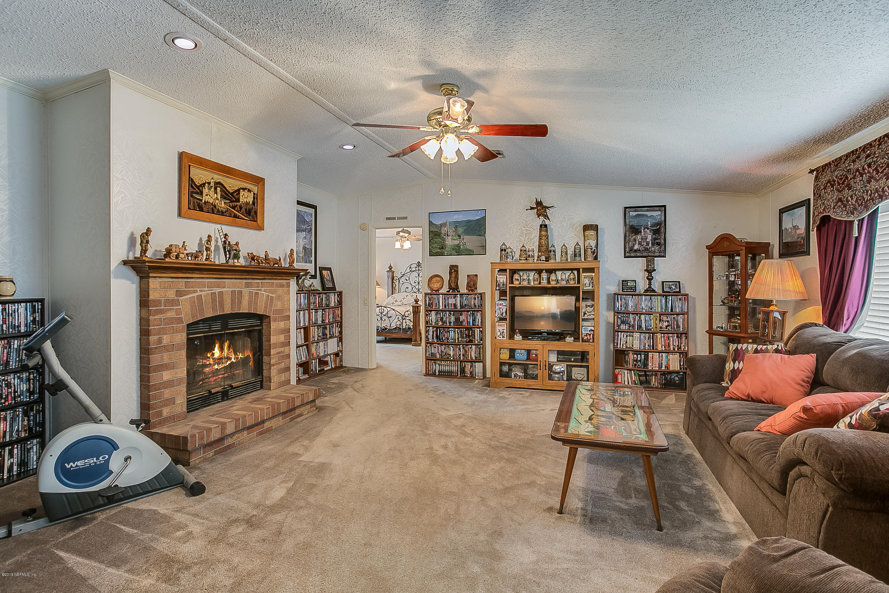 13278 Grover Road Jacksonville, FL 32226 - Photo 9 of 26 a living room with furniture a fireplace and a flat screen tv