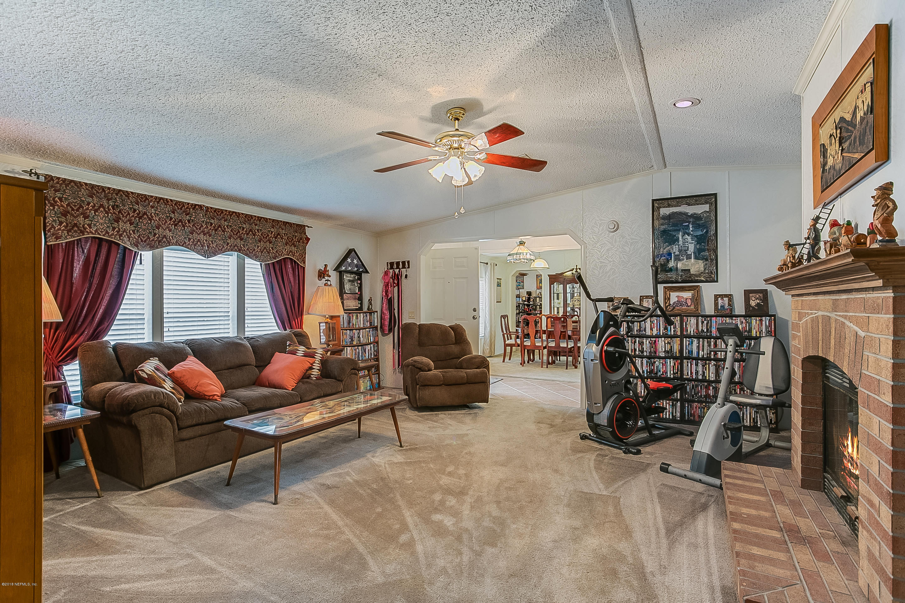 13278 Grover Road Jacksonville, FL 32226 - Photo 10 of 26 a living room with furniture a fireplace and a chandelier