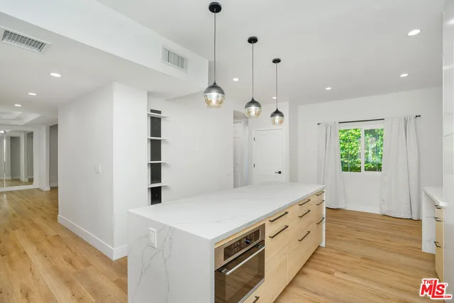a kitchen with a stove and a wooden floor