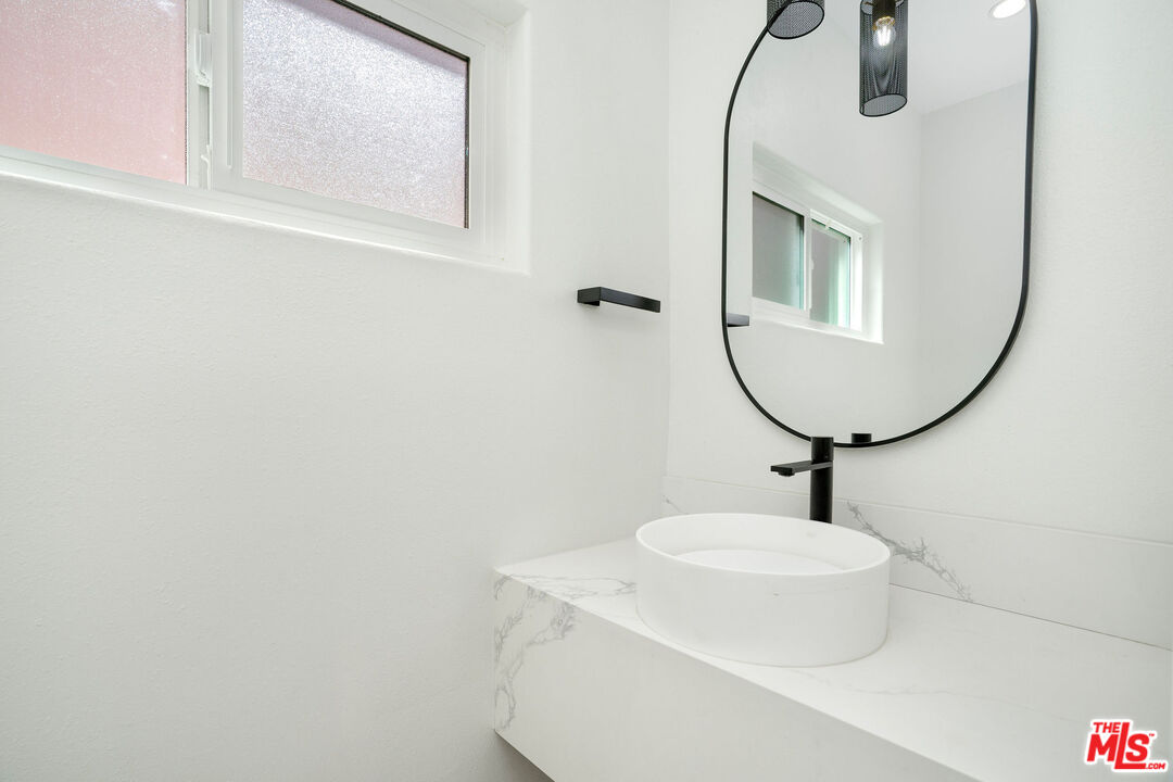 5923 Etiwanda Avenue, Unit 106 Tarzana, CA 91356 - Photo 11 of 27 a bathroom with a sink a mirror and vanity