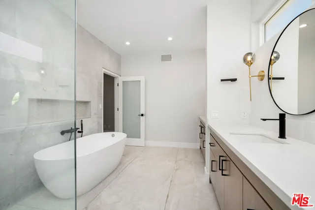 a bathroom with a sink a tub and a mirror