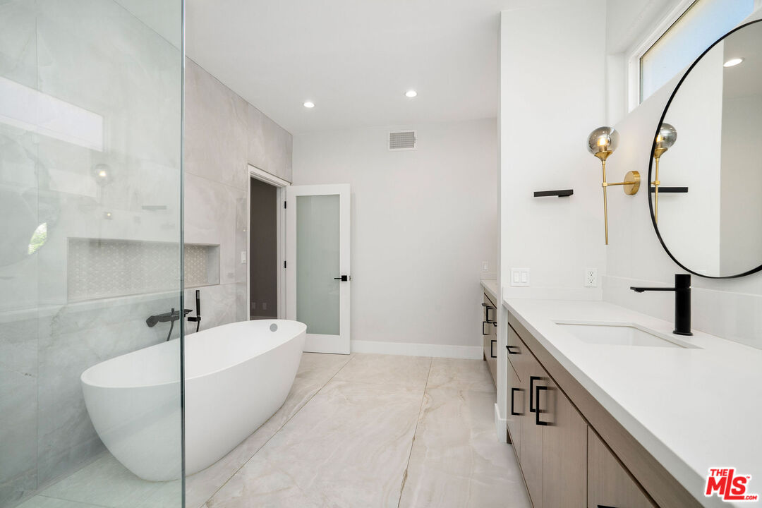 5923 Etiwanda Avenue, Unit 106 Tarzana, CA 91356 - Photo 16 of 27 a bathroom with a sink a tub and a mirror