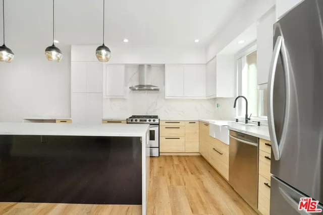 a kitchen with kitchen island a sink stainless steel appliances and cabinets