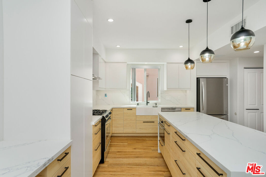 5923 Etiwanda Avenue, Unit 106 Tarzana, CA 91356 - Photo 3 of 27 a spacious bathroom with a double vanity sink and a large mirror