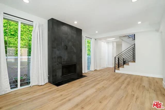 a view of empty room with wooden floor and a fireplace