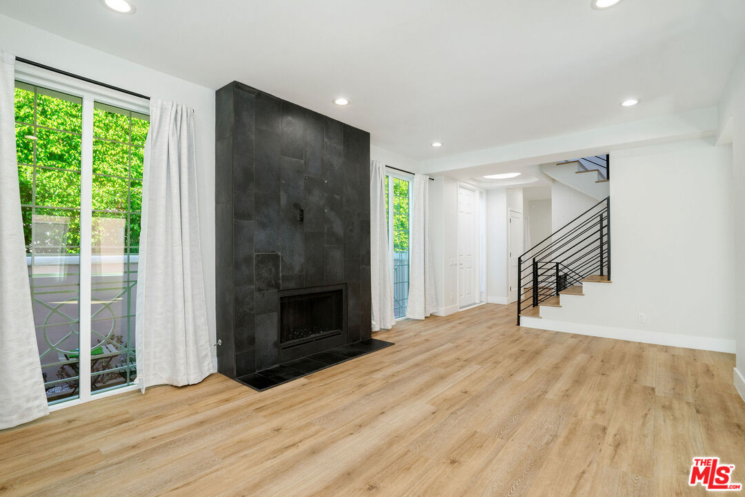 5923 Etiwanda Avenue, Unit 106 Tarzana, CA 91356 - Photo 4 of 27 a view of empty room with wooden floor and a fireplace