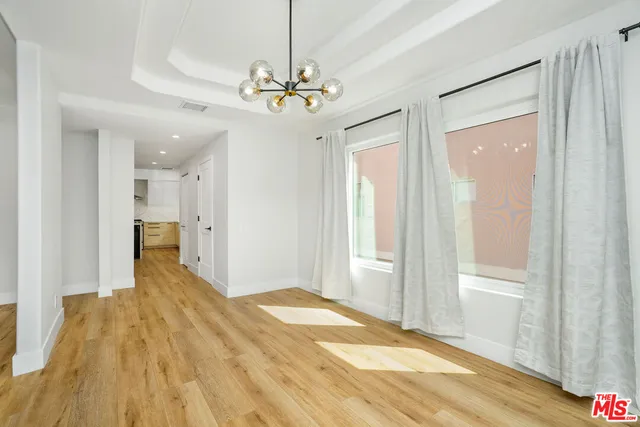 a view of a livingroom with a chandelier fan and windows