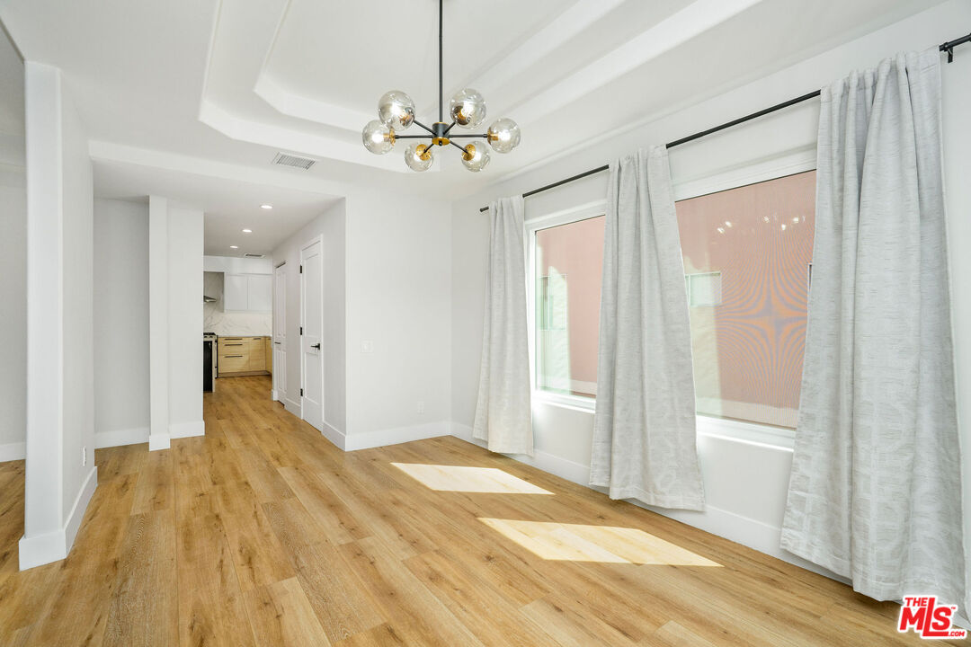 5923 Etiwanda Avenue, Unit 106 Tarzana, CA 91356 - Photo 7 of 27 a view of a livingroom with a chandelier fan and windows