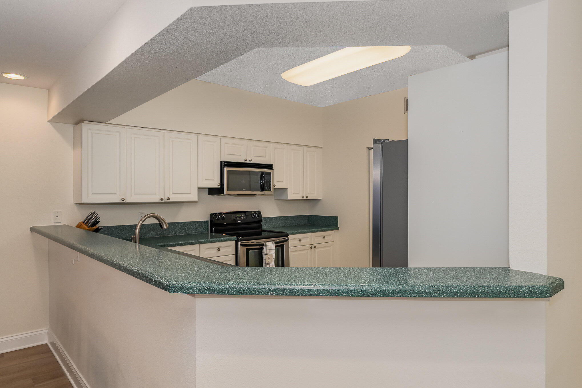 125 Pulsipher Avenue, Unit 402 Cocoa Beach, FL 32931 - Photo 12 of 34 a kitchen with stainless steel appliances granite countertop a sink stove and refrigerator